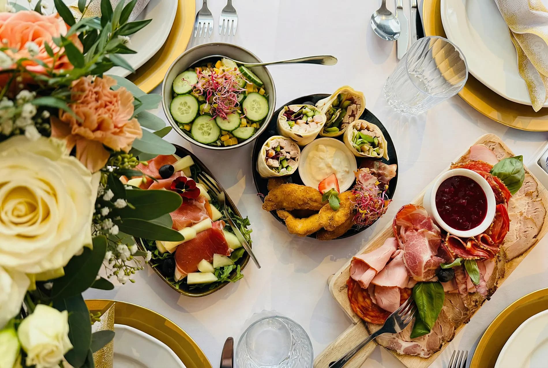Elegancko podane dania — sałatki, kwiaty i złote talerze