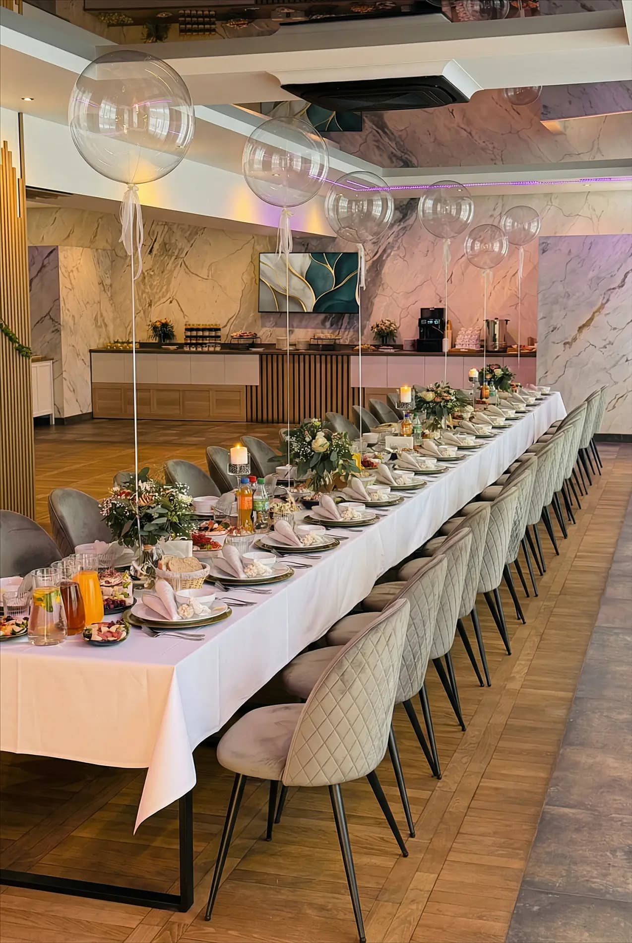 Długi stół z balonami i marmurowym tłem